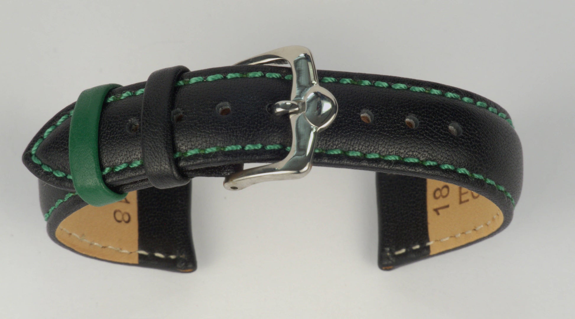 Lederuhrenarmband (Schwarz mit grüner Naht) zu einem Bogen geformt mit weißem Hintergrund. Detaillierte Nahaufnahme.