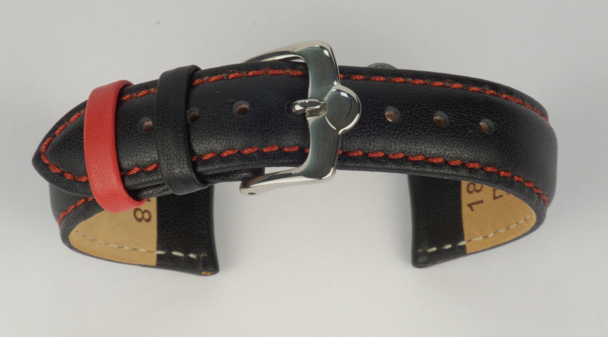 Lederuhrenarmband (Schwarz mit roter Naht) zu einem Bogen geformt mit weißem Hintergrund. Detaillierte Nahaufnahme.