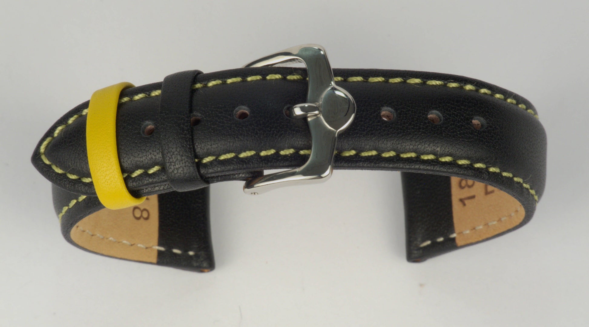 Lederuhrenarmband (Schwarz mit gelber Naht) zu einem Bogen geformt mit weißem Hintergrund. Detaillierte Nahaufnahme.