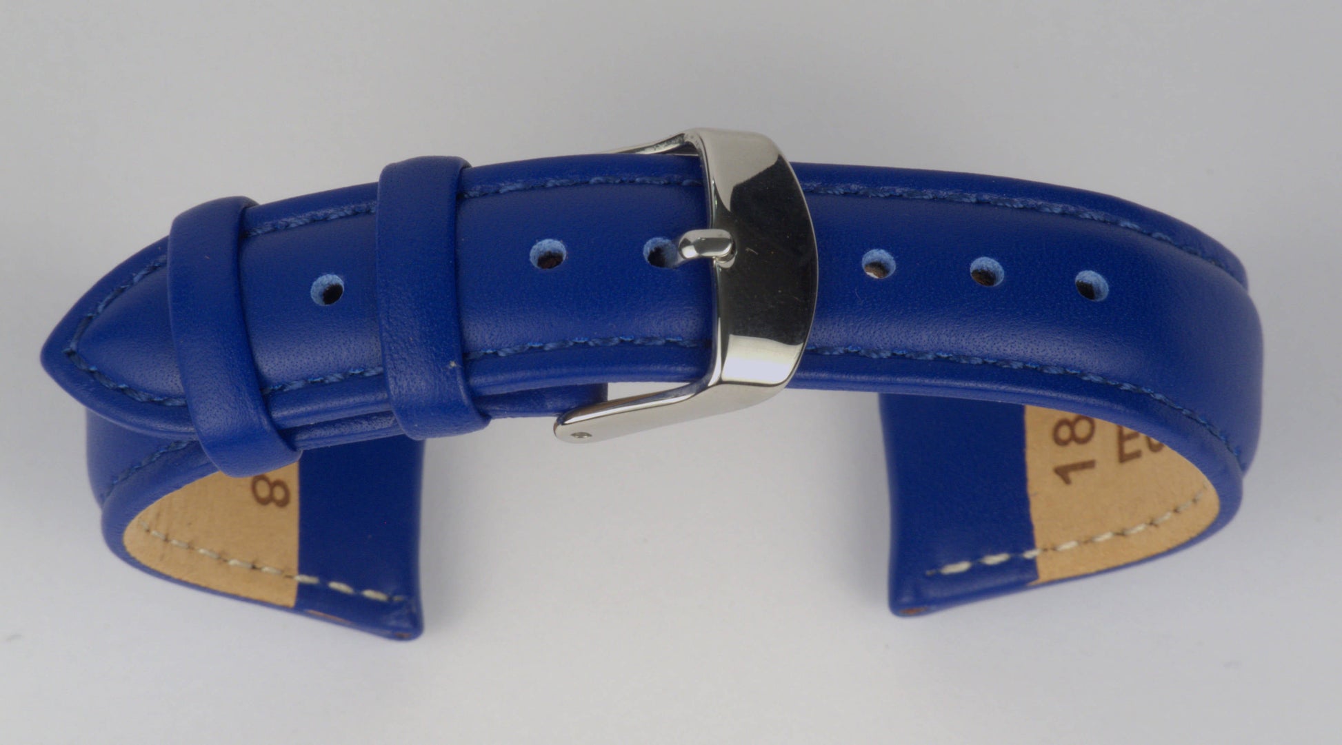 Lederuhrenarmband (Blau) zu einem Bogen geformt mit weißem Hintergrund. Detaillierte Nahaufnahme.