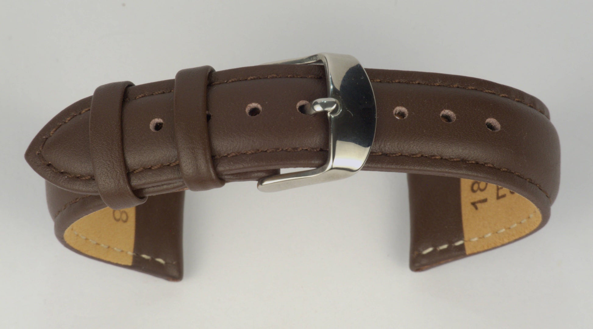 Lederuhrenarmband (Dunkelbraun) zu einem Bogen geformt mit weißem Hintergrund. Detaillierte Nahaufnahme.