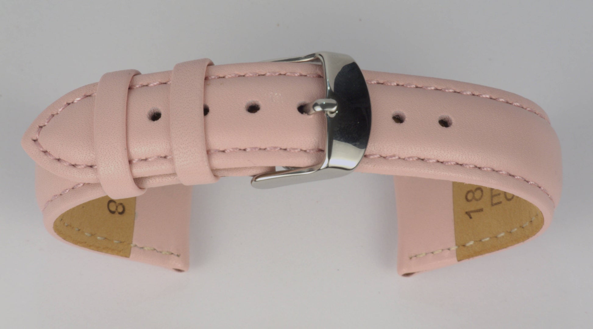 Lederuhrenarmband (Pink) zu einem Bogen geformt mit weißem Hintergrund. Detaillierte Nahaufnahme.