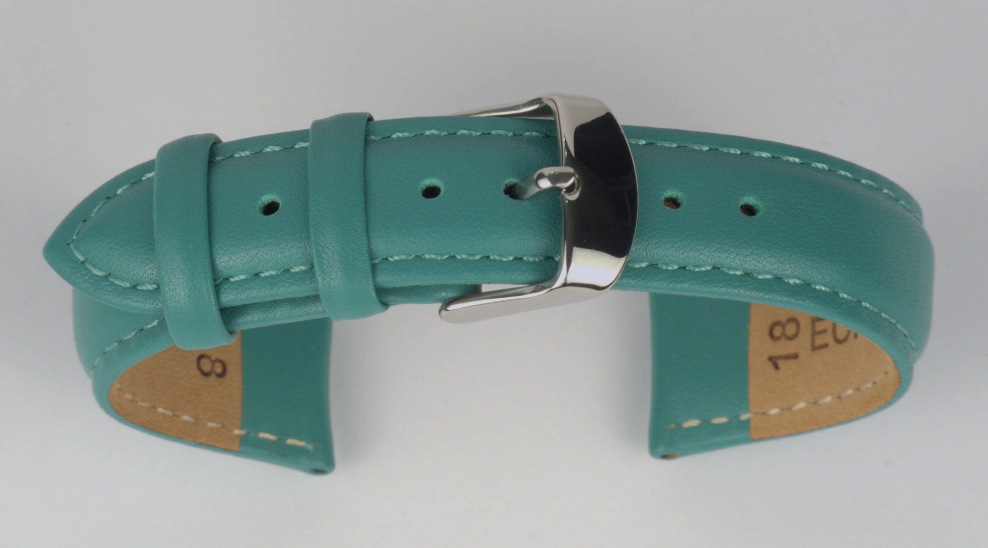 Lederuhrenarmband (Türkis) zu einem Bogen geformt mit weißem Hintergrund. Detaillierte Nahaufnahme.