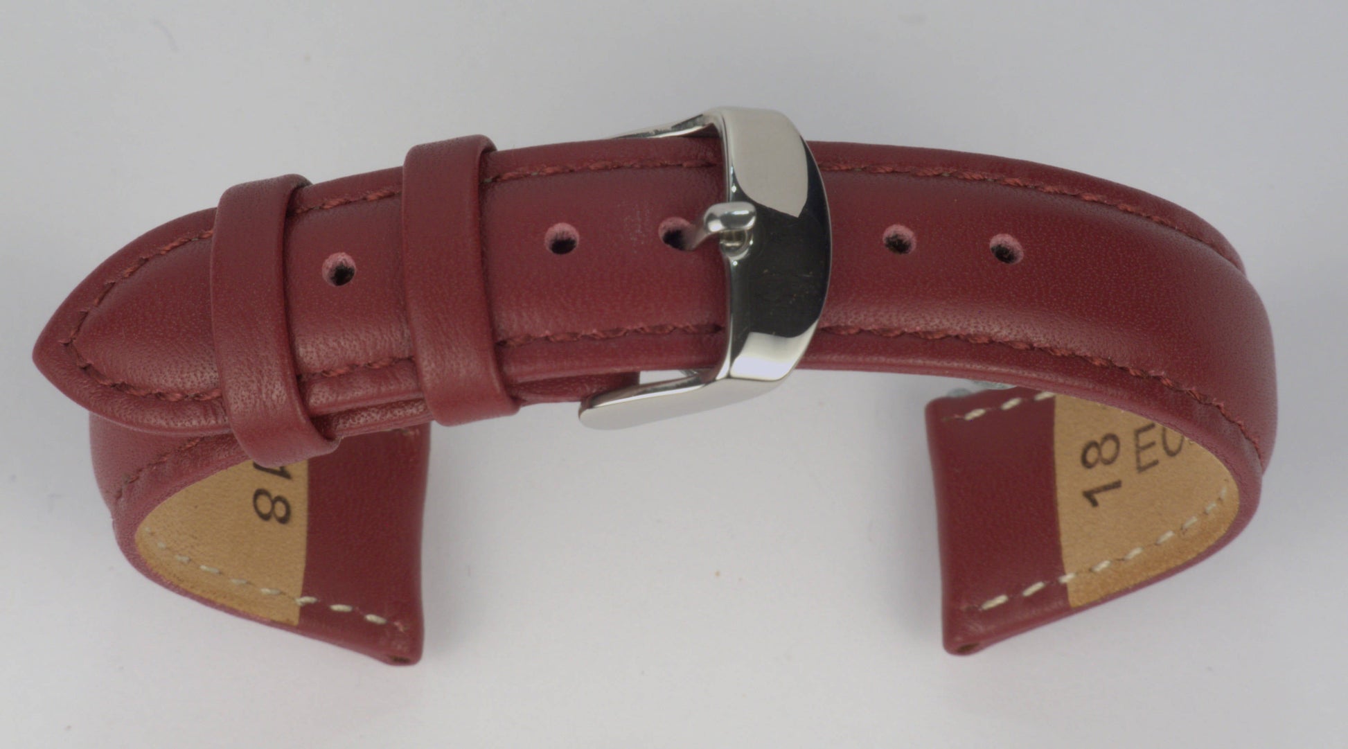 Lederuhrenarmband (Weinrot) zu einem Bogen geformt mit weißem Hintergrund. Detaillierte Nahaufnahme.