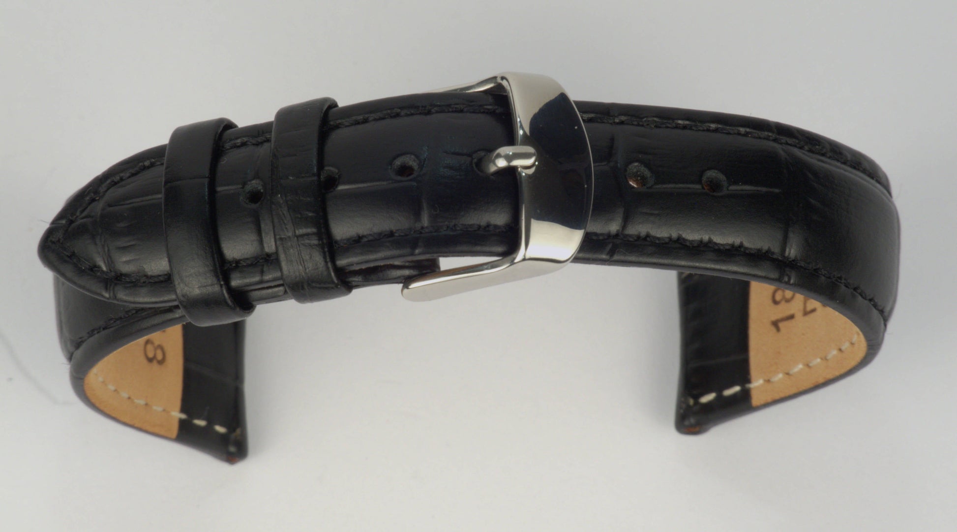 Lederuhrenarmband (Schwarz) zu einem Bogen geformt mit weißem Hintergrund. Detaillierte Nahaufnahme.