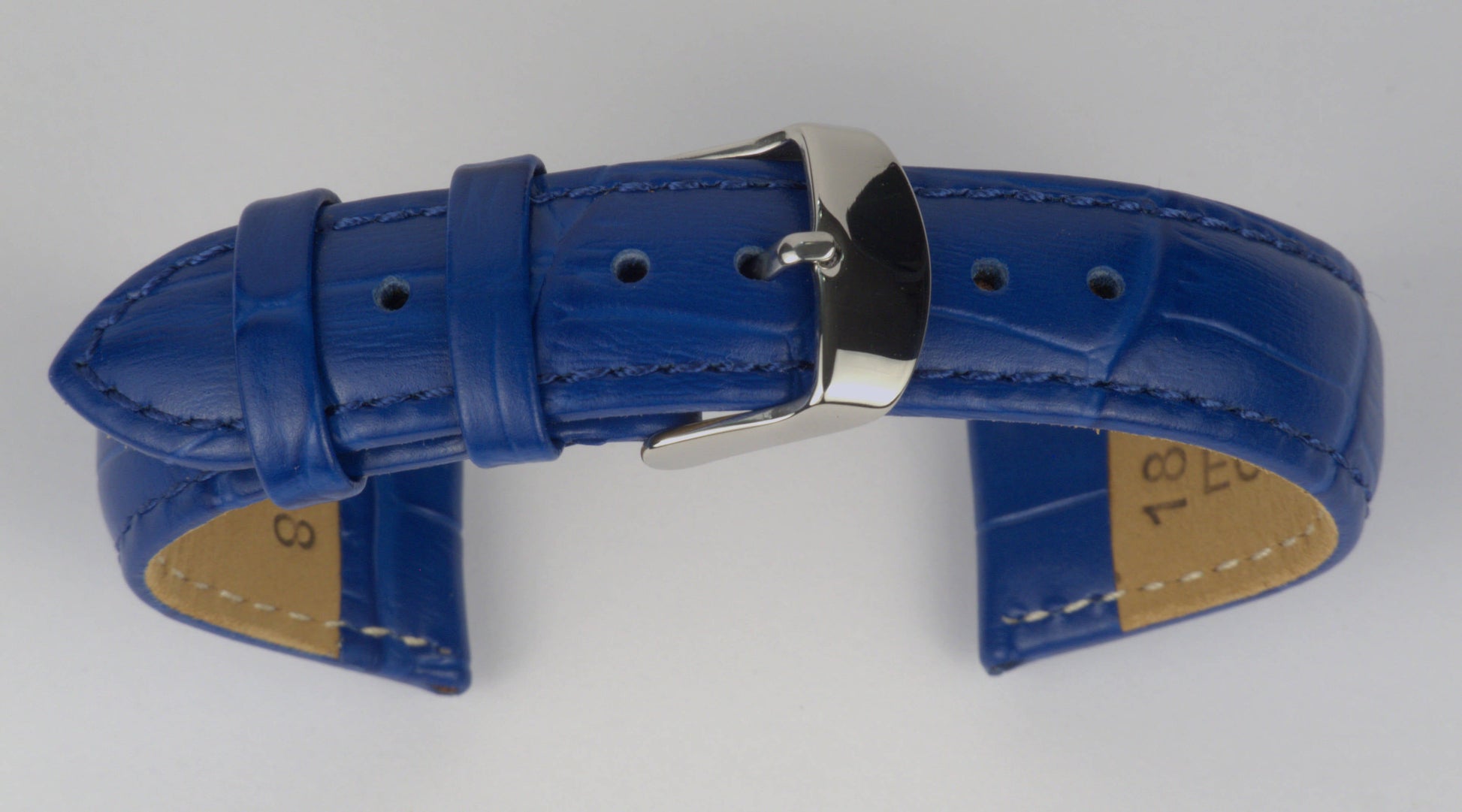 Lederuhrenarmband (Blau) zu einem Bogen geformt mit weißem Hintergrund. Detaillierte Nahaufnahme.