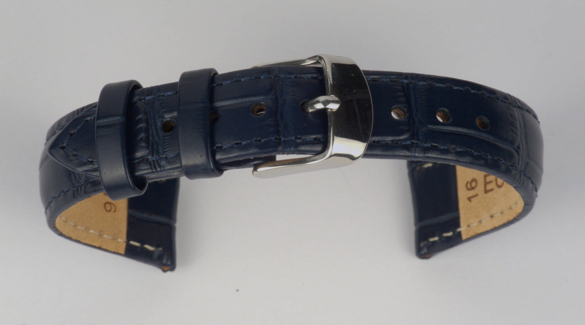 Lederuhrenarmband (Dunkelblau) zu einem Bogen geformt mit weißem Hintergrund. Detaillierte Nahaufnahme.