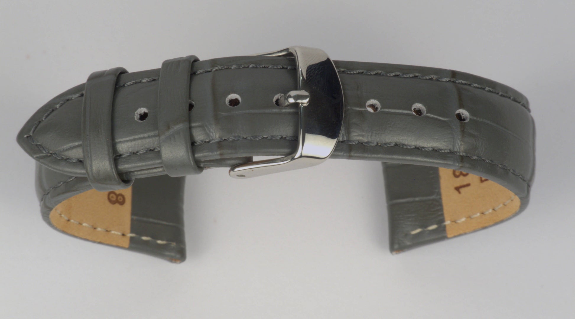 Lederuhrenarmband (Dunkelgrau) zu einem Bogen geformt mit weißem Hintergrund. Detaillierte Nahaufnahme.