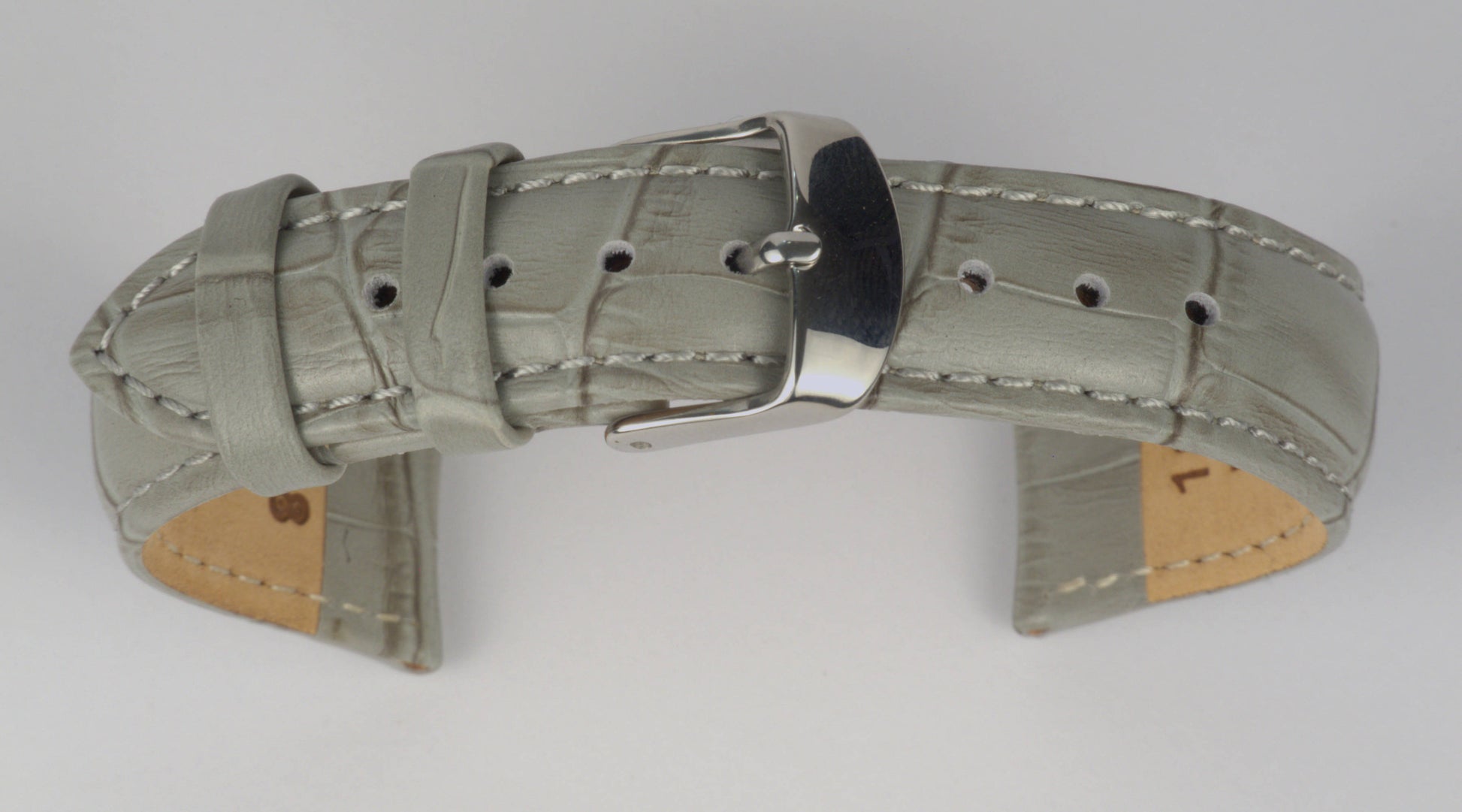 Lederuhrenarmband (Hellgrau) zu einem Bogen geformt mit weißem Hintergrund. Detaillierte Nahaufnahme.