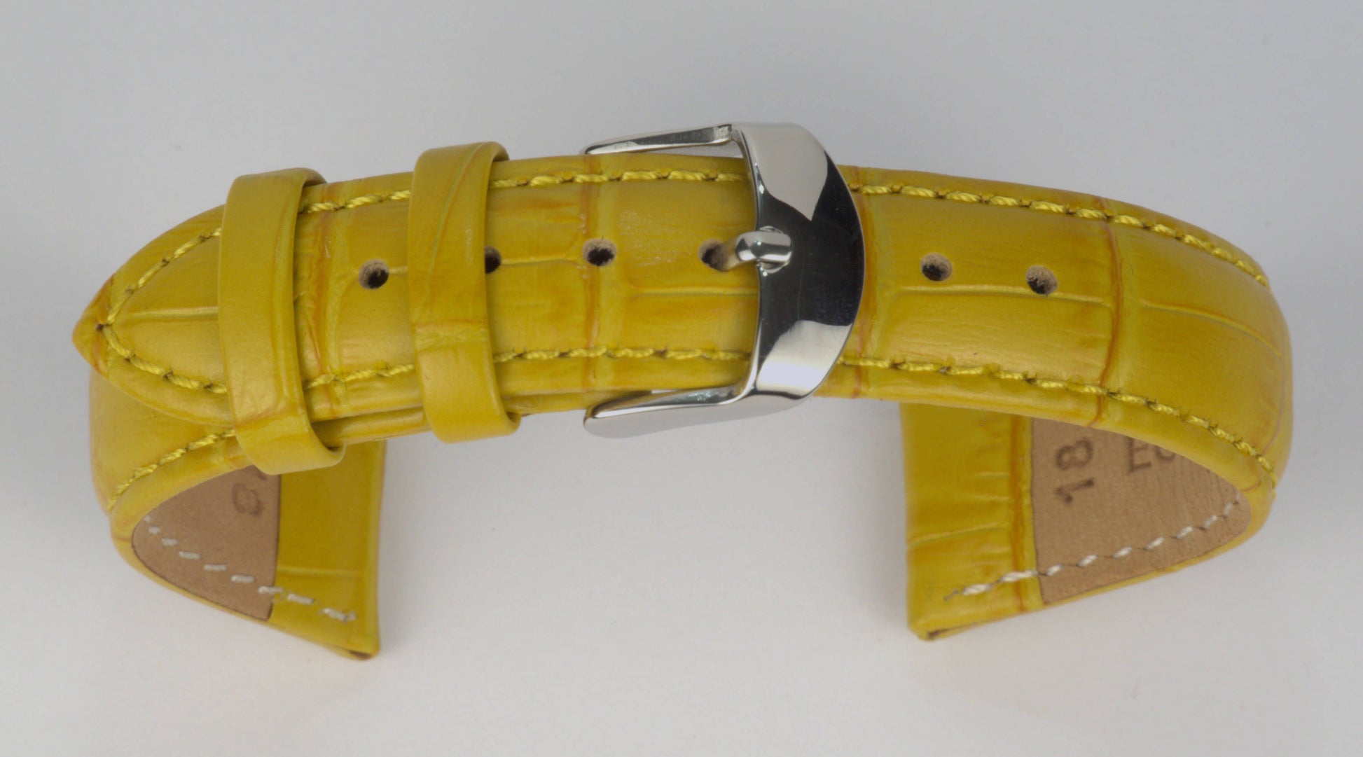 Lederuhrenarmband (Gelb) zu einem Bogen geformt mit weißem Hintergrund. Detaillierte Nahaufnahme.