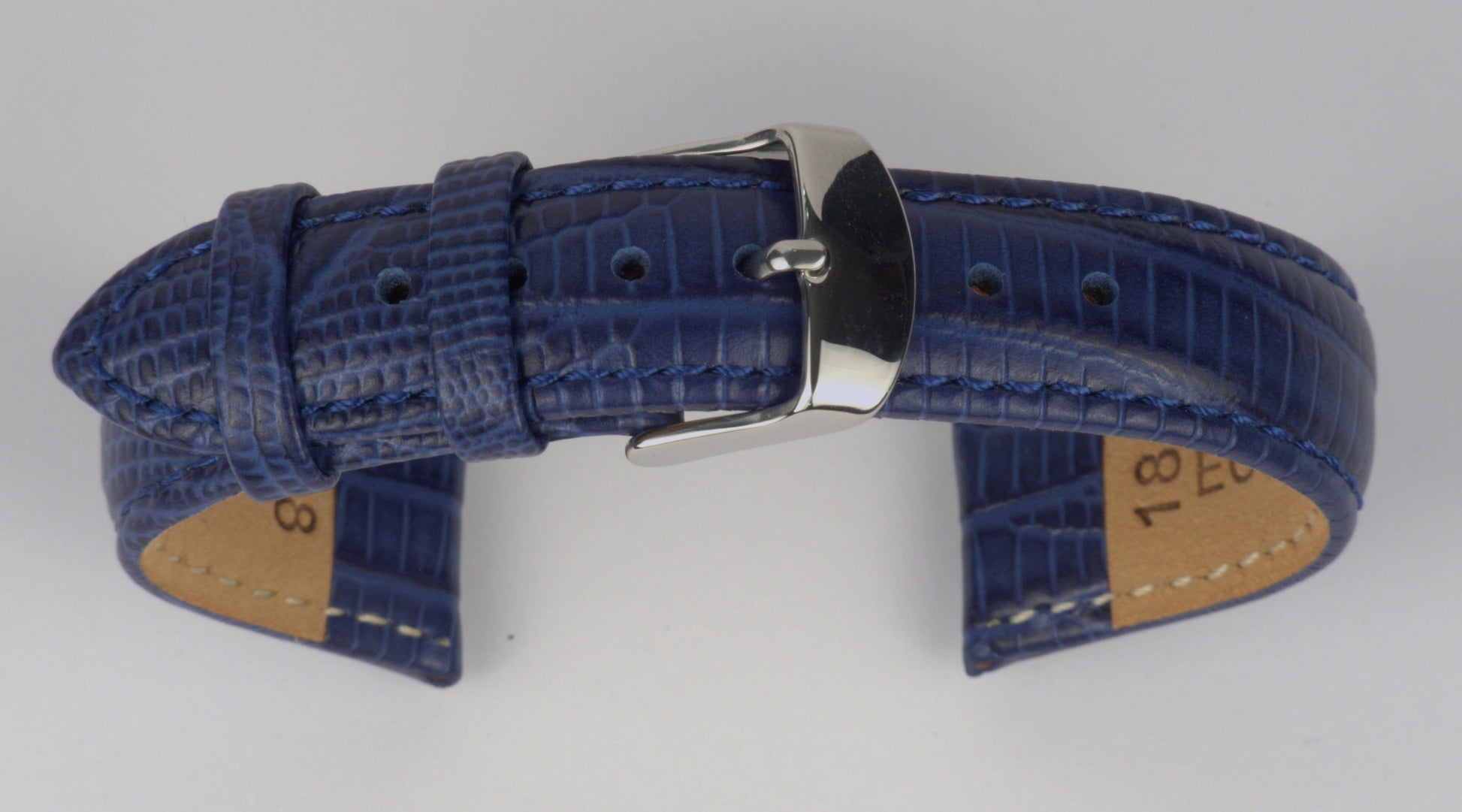 Lederuhrenarmband (Dunkelblau) zu einem Bogen geformt mit weißem Hintergrund. Detaillierte Nahaufnahme.