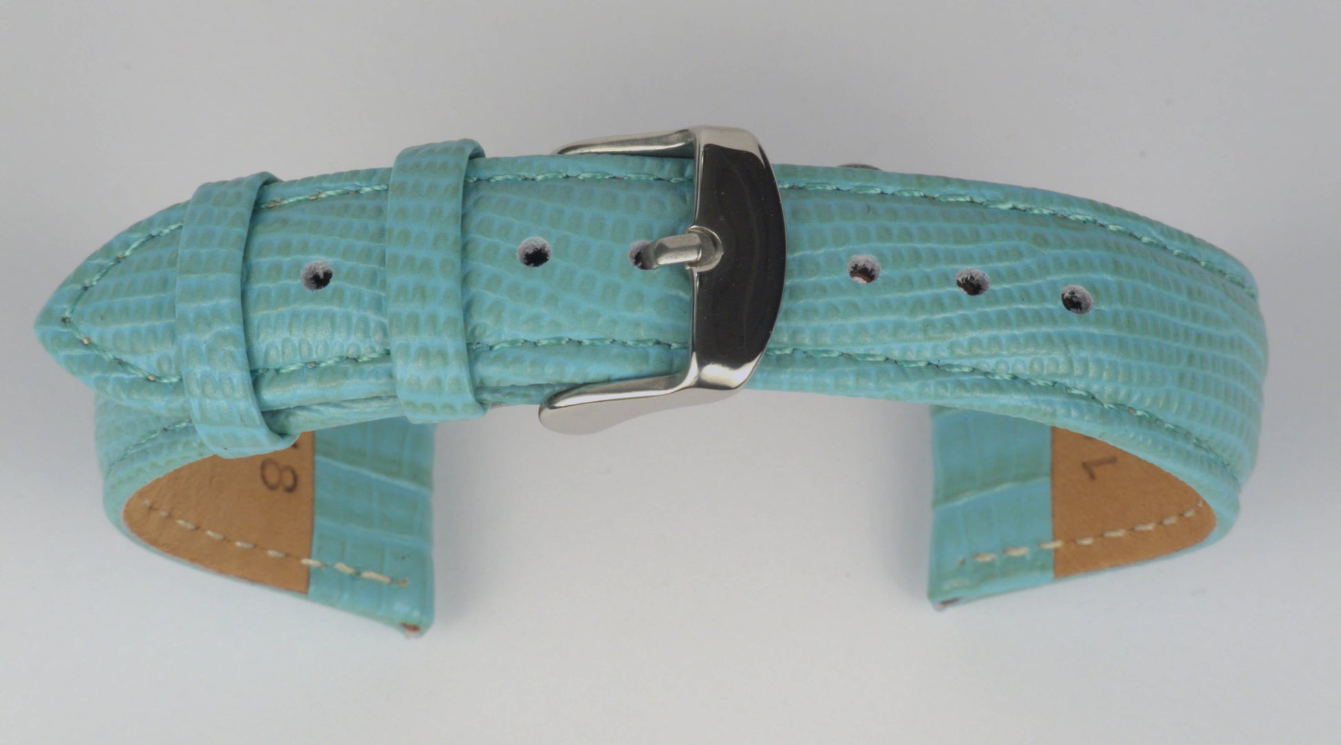 Lederuhrenarmband (Türkis) zu einem Bogen geformt mit weißem Hintergrund. Detaillierte Nahaufnahme.