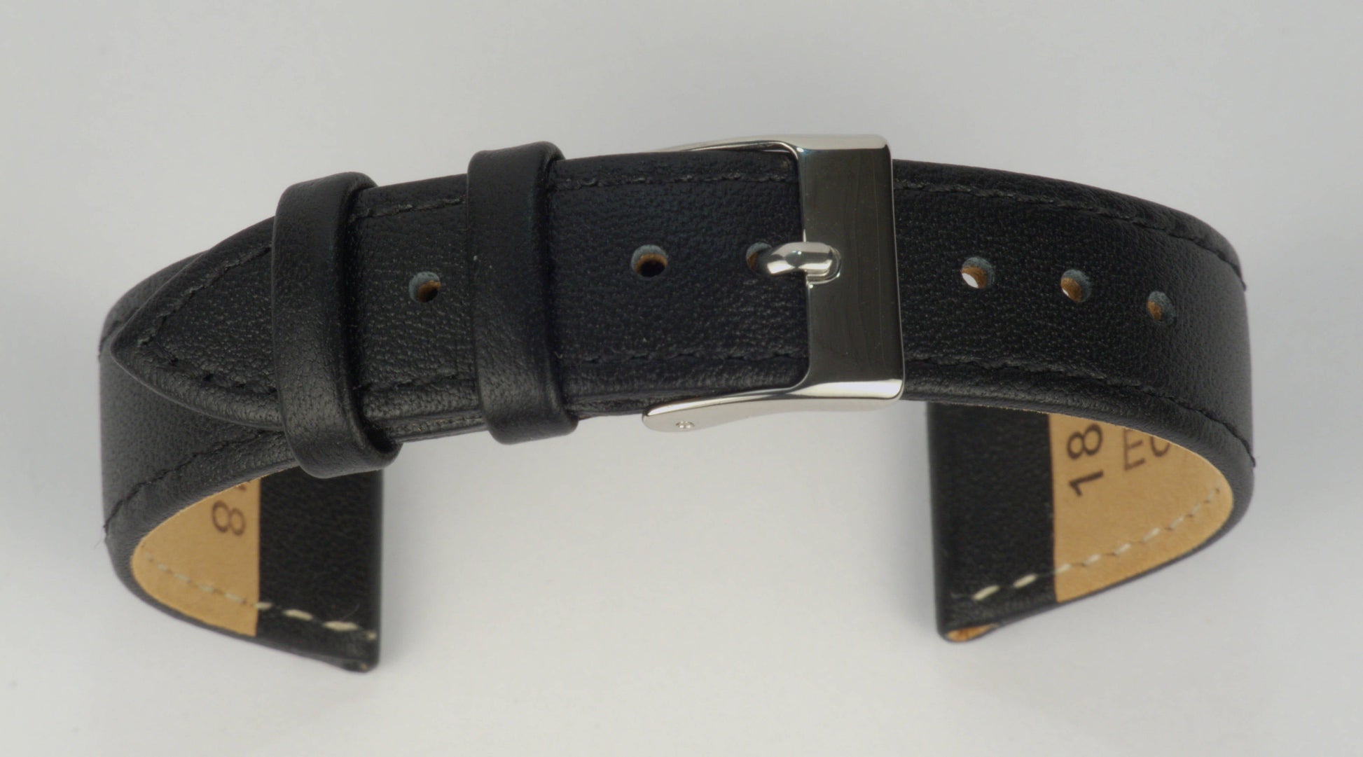 Lederuhrenarmband (Schwarz) zu einem Bogen geformt mit weißem Hintergrund. Detaillierte Nahaufnahme.