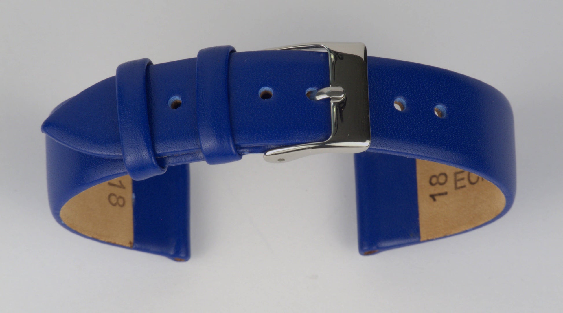 Lederuhrenarmband (Blau) zu einem Bogen geformt mit weißem Hintergrund. Detaillierte Nahaufnahme.