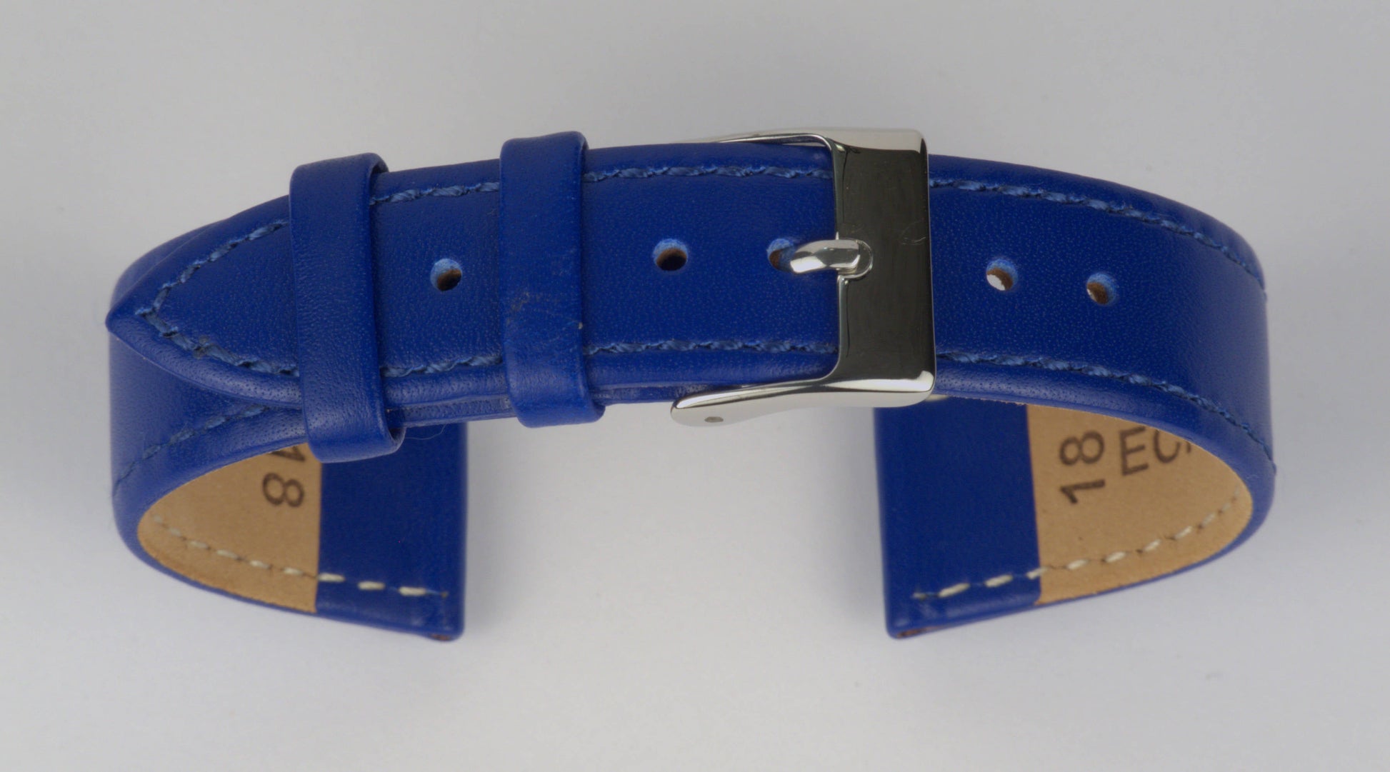 Lederuhrenarmband (Blau) zu einem Bogen geformt mit weißem Hintergrund. Detaillierte Nahaufnahme.