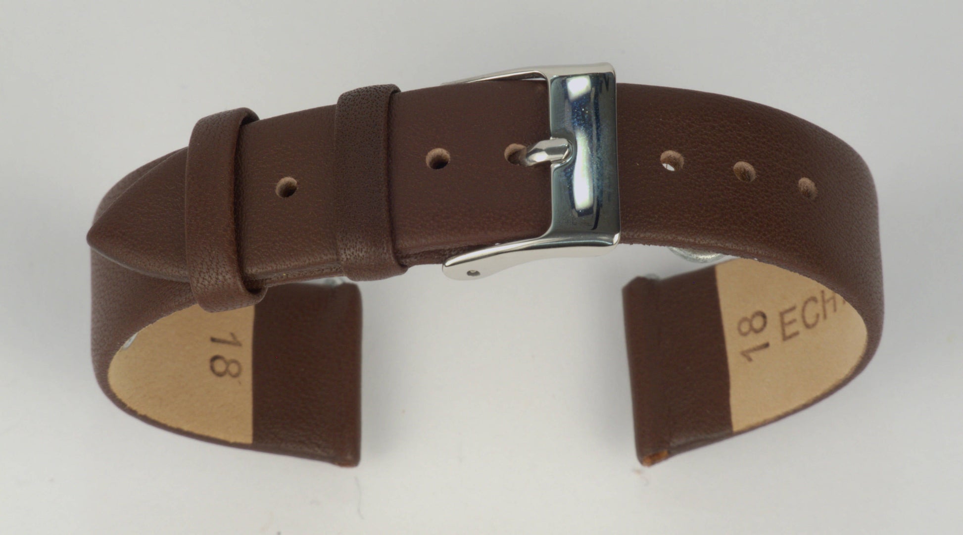 Lederuhrenarmband (Dunkelbraun) zu einem Bogen geformt mit weißem Hintergrund. Detaillierte Nahaufnahme.