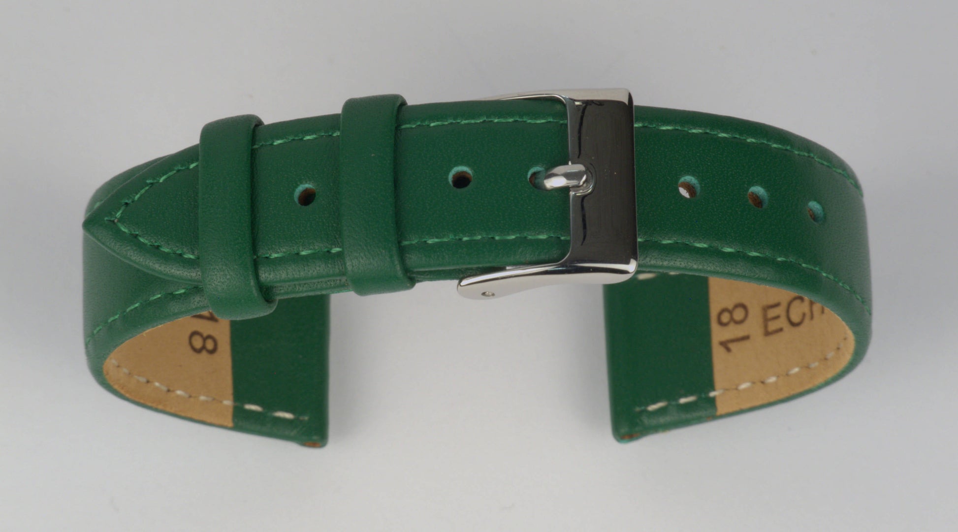 Lederuhrenarmband (Grün) zu einem Bogen geformt mit weißem Hintergrund. Detaillierte Nahaufnahme.