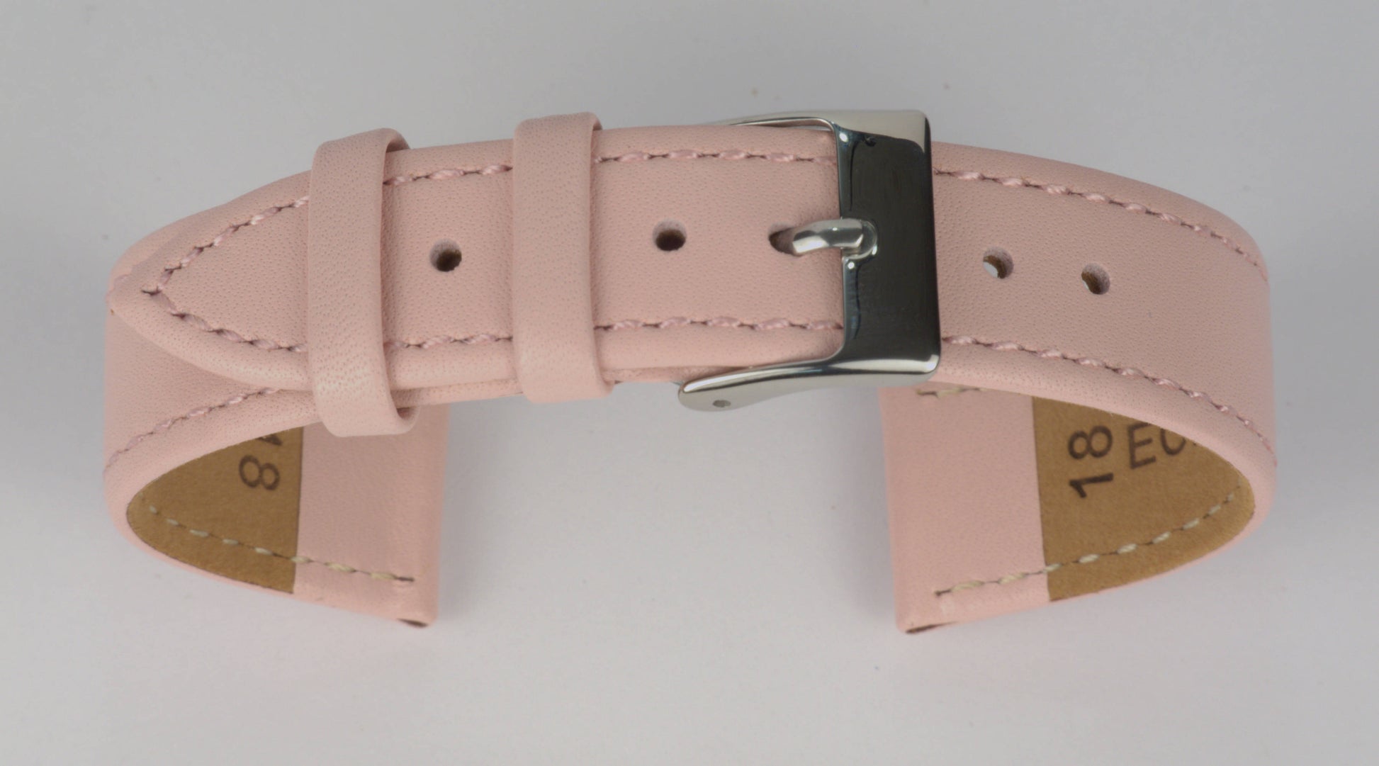 Lederuhrenarmband (Pink) zu einem Bogen geformt mit weißem Hintergrund. Detaillierte Nahaufnahme.