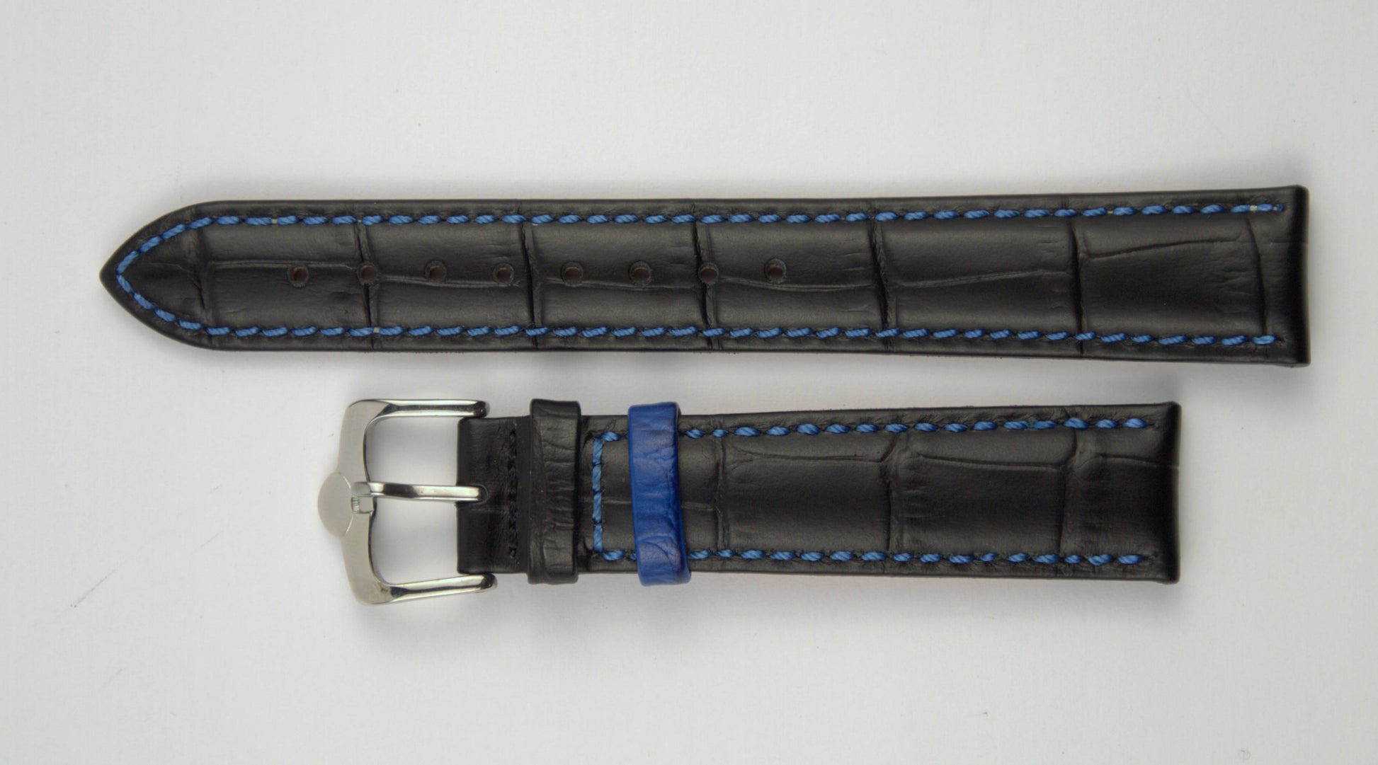 Lederuhrenarmband (Schwarz mit blauer Naht) flach aufgelegt mit weißem Hintergrund. Detaillierte Nahaufnahme.