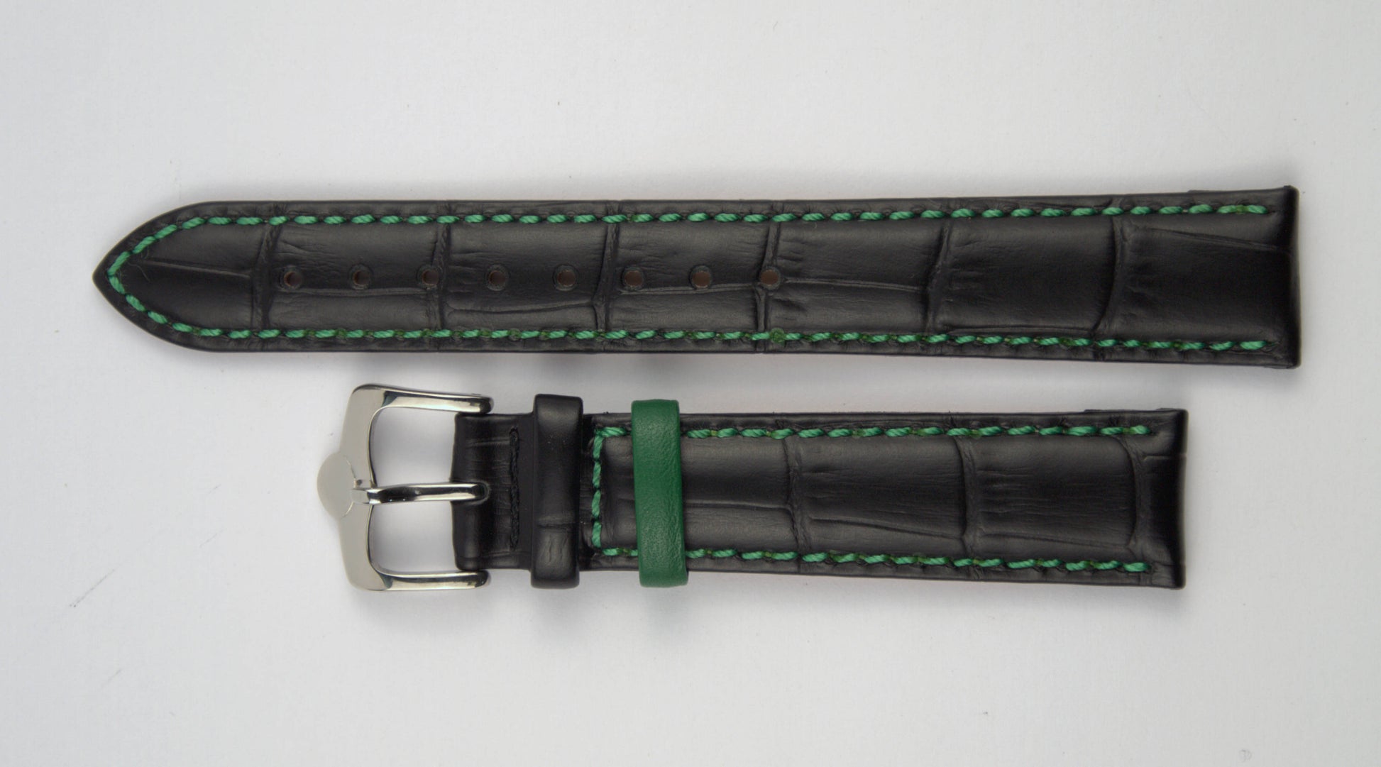 Lederuhrenarmband (Schwarz mit grüner Naht) flach aufgelegt mit weißem Hintergrund. Detaillierte Nahaufnahme.