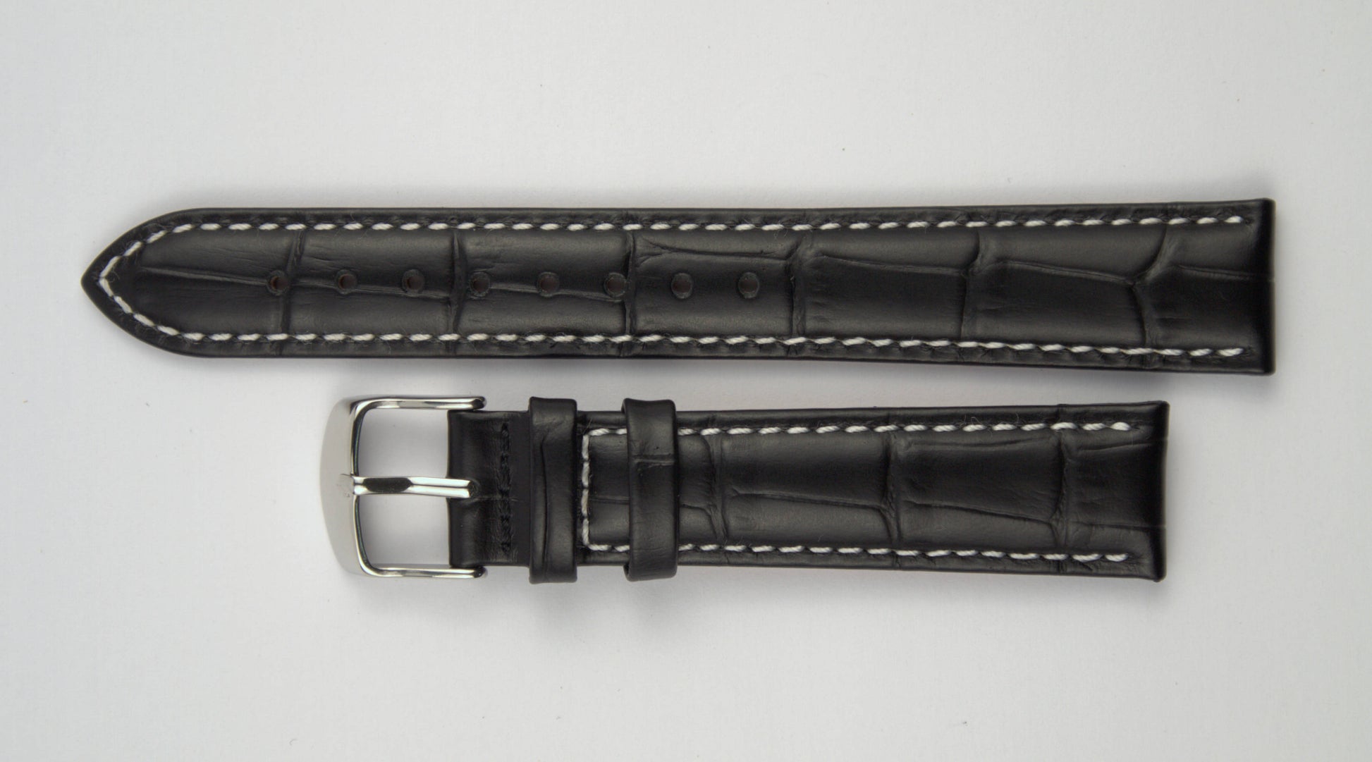 Lederuhrenarmband (Schwarz mit weißer Naht) flach aufgelegt mit weißem Hintergrund. Detaillierte Nahaufnahme.
